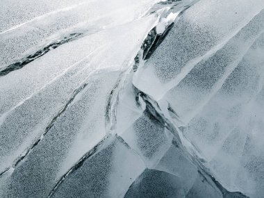 Soyut buz dokusu. Soğuk zeminde çatlaklar olan mavi soğuk bir arka plan. Yakın plan..