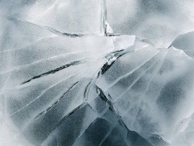 Soyut buz dokusu. Soğuk zeminde çatlaklar olan mavi soğuk bir arka plan. Yakın plan..