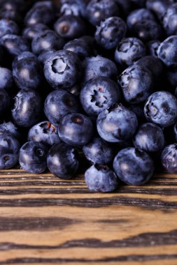 Olgun yaban mersinleri kahverengi arkaplanı kaplar.