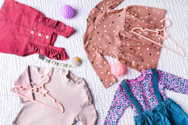 Baby Flicka Kläder Med Napp Och Leksaker Vit Strukturerad Bakgrund — Stockfoto
