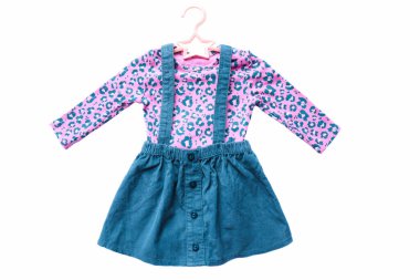 Beyaz arka planda, askıda pembe tulumlu bebek eteği..