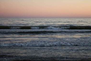 Karadeniz 'de pembe gün batımı. Yaz akşamları denizde dalgalar.
