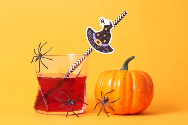 Red drink in aglass and pumpkin with spiders. Halloween concept