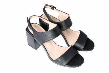 Beyaz arka planda siyah deri topuklu sandaletler..