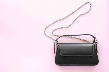 Pembe zincire vurulmuş siyah deri bir çanta..