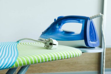 Mavi modern elektrikli ütü odadaki ütü masasında..