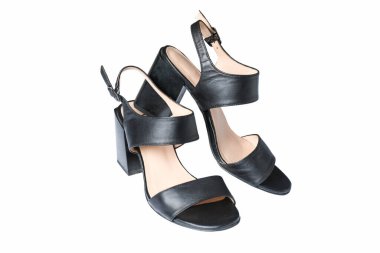 Beyaz arka planda siyah deri topuklu sandaletler..