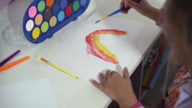 Yetenekli Yaratıcı Çocuk Kadın Sanatçı, Gökkuşağı Gökyüzünü Kağıda Çiziyor, Boyaları Kullanarak Fırça Renkli Yaratıyor, Evde Çocuk Çizimi Yapıyor. Ressam Soyut Modern Sanat Oluşturuyor. Çocukluk