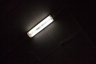 Tavandaki lamba karanlıkta parlıyor. Elektrik ışığı.