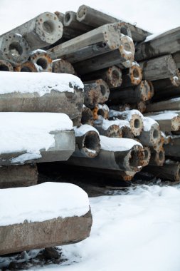 Paslı metal takviyeli beton direkler (direkler, kalınlar) yığını. İnşaat malzemesi.