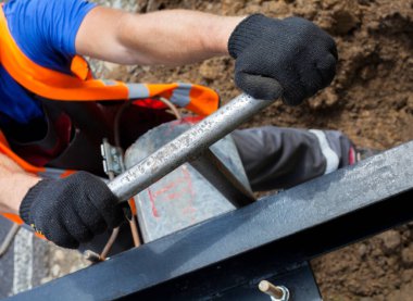İşçi ingiliz anahtarını çeviriyor. Ukrayna Karpat Dağları 'nda yolculuk boyunca yeni elektrik direklerinin (iletim, elektrik direklerinin) kurulması