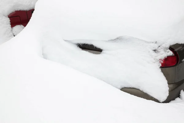 stock image Gray passenger car in the snowdrift (snow bank) on the parking lot. Car covered with snow after the snowstorm in winter.