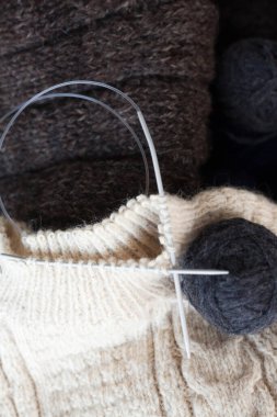 Örgü örüyorum. Yünlü iplik toplarıyla örgü iğneleri. Örgü kumaş..