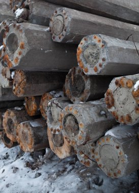 Paslı metal takviyeli beton direkler (direkler, kalınlar) yığını. İnşaat malzemesi.