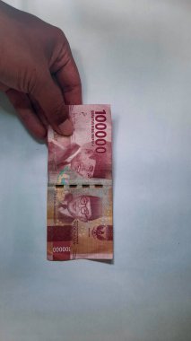 Ellerinde Endonezya parası, izole edilmiş beyaz