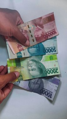 Ellerinde Endonezya parası, izole edilmiş beyaz