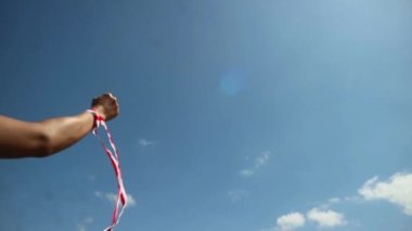 Eller kırmızı ve beyaz kurdele takıyor, gökyüzü arkaplanı, Endonezya bağımsızlık günü konsepti