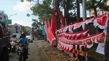 Malang, Endonezya - 23 Temmuz 2023: Bağımsızlık Günü kutlamaları için penjual bendera dan spanduk Merah putih veya Endonezya bayrağı satıcısı