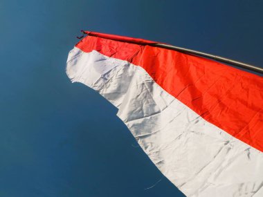 Yol boyunca mavi gökyüzü arkaplanlı kırmızı ve beyaz bayrak. Endonezya bağımsızlık günü konsepti.