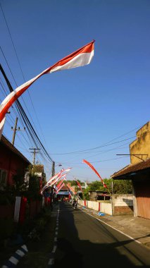 Yol boyunca mavi gökyüzü arkaplanlı kırmızı ve beyaz bayrak. Endonezya bağımsızlık günü konsepti.
