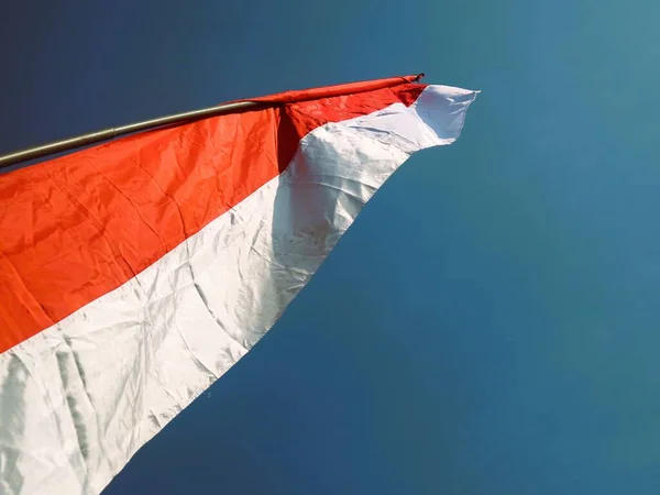 Red and white flag banner along the road with blue sky background. Indonesia independence day celebration concept.