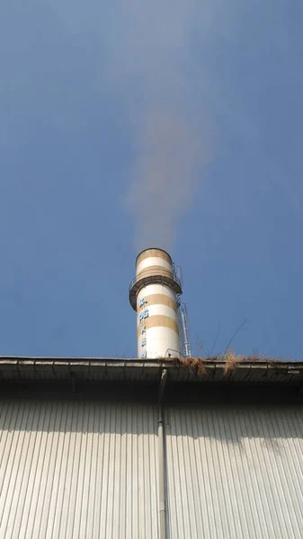 青い空の背景に対する煙と煙突 — ストック写真