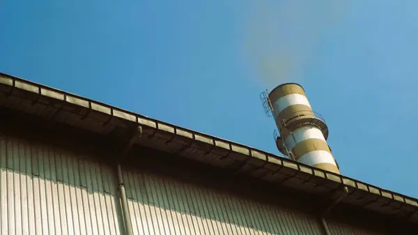 蓝天背景下的烟和烟囱 — 图库照片