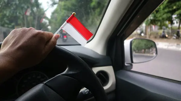 举着印度尼西亚国旗在车里庆祝印度尼西亚独立日 — 图库照片