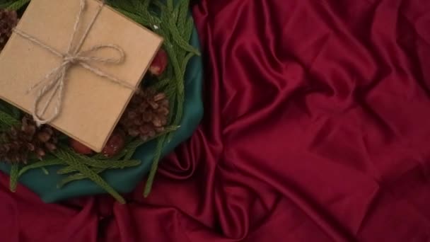 圣诞节背景360度旋转 冷杉叶 干松和礼品盒在红色背景下旋转 新年礼物 节日及假日购物的概念 — 图库视频影像