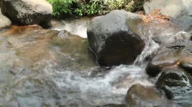 Kaybedilen su, farklı büyüklükteki taşlarla dolu bir nehirden akar. Kayalık nehir.