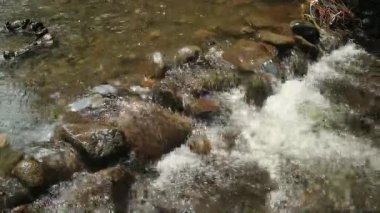 Kaybedilen su, farklı büyüklükteki taşlarla dolu bir nehirden akar. Kayalık nehir.
