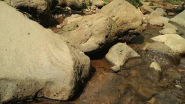 Kaybedilen su, farklı büyüklükteki taşlarla dolu bir nehirden akar. Kayalık nehir.
