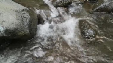 Kaybedilen su, farklı büyüklükteki taşlarla dolu bir nehirden akar. Kayalık nehir.