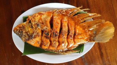 Muz yapraklarıyla servis edilen ızgara balık.