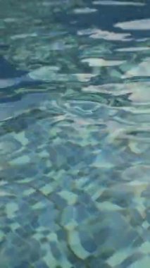 Yüzme havuzundaki dalgalı suyun dikey videosu