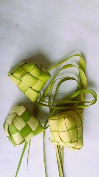 Ketupat Pouches on white Background - Ketupat is a type of dumpling made from rice packed inside a diamond-shaped container of woven palm leaf pouch, traditional Muslim food during the celebration of Eid al-Fitr