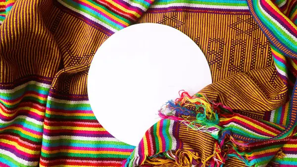 White round shape for text decorated with handmade woven fabric, colorful textured textile background, unique pattern from Indonesia, copy space