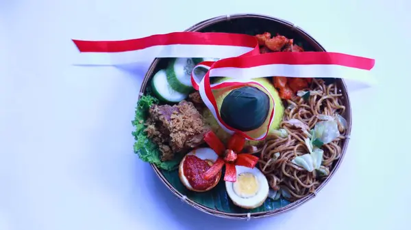 Tumpeng merah putih, sarı koni şekilli pirinç, 17 Ağustos 'ta Endonezya' nın bağımsızlık günü kutlamalarında servis edilen kırmızı ve beyaz kurdeleyle süslenmiş.