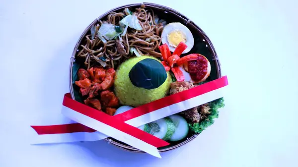 Tumpeng merah putih, sarı koni şekilli pirinç, 17 Ağustos 'ta Endonezya' nın bağımsızlık günü kutlamalarında servis edilen kırmızı ve beyaz kurdeleyle süslenmiş.