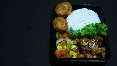 Nasi Bento 'nun öğle yemeği paketinde pirinç, tavuk ve sebze var. Endonezya Başkanı Prabowo hükümeti okul çocuklarına ücretsiz öğle yemeği sağlıyor.