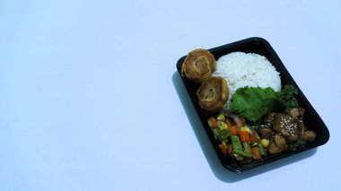 Nasi Bento 'nun öğle yemeği paketinde pirinç, tavuk ve sebze var. Endonezya Başkanı Prabowo hükümeti okul çocuklarına ücretsiz öğle yemeği sağlıyor.