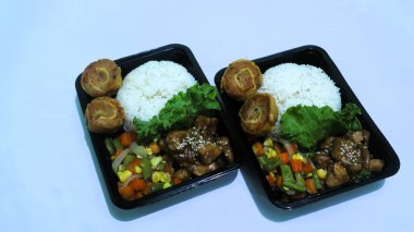 Nasi Bento 'nun öğle yemeği paketinde pirinç, tavuk ve sebze var. Endonezya Başkanı Prabowo hükümeti okul çocuklarına ücretsiz öğle yemeği sağlıyor.