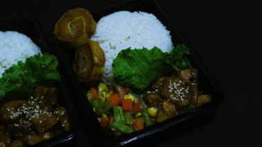 Nasi Bento 'nun öğle yemeği paketinde pirinç, tavuk ve sebze var. Endonezya Başkanı Prabowo hükümeti okul çocuklarına ücretsiz öğle yemeği sağlıyor.