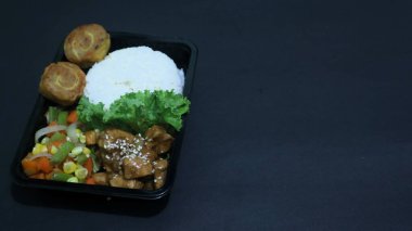 Nasi Bento 'nun öğle yemeği paketinde pirinç, tavuk ve sebze var. Endonezya Başkanı Prabowo hükümeti okul çocuklarına ücretsiz öğle yemeği sağlıyor.