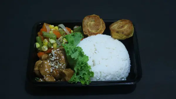 Nasi Bento 'nun öğle yemeği paketinde pirinç, tavuk ve sebze var. Endonezya Başkanı Prabowo hükümeti okul çocuklarına ücretsiz öğle yemeği sağlıyor.