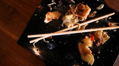 Ahşap masa arkaplanlı, çubuklu erişte ve yemek artıkları.