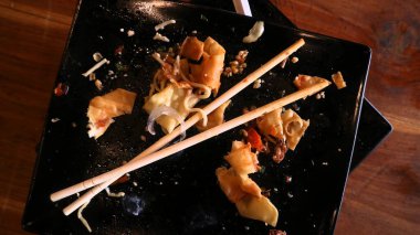 Ahşap masa arkaplanlı, çubuklu erişte ve yemek artıkları.