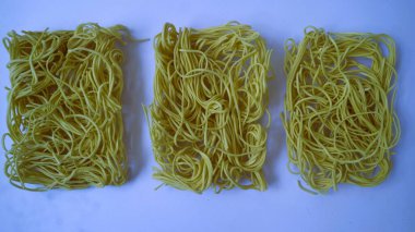 Beyaz arka planda izole edilmiş kuru erişteler. Çiğ ramen eriştesi, kopyalama alanı