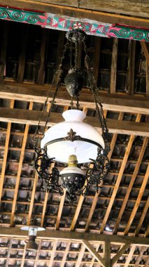 Eski bir Cava lambası, çatıda asılı, Endonezya mirası, mavi gökyüzü sırt çantasıyla, kopyalama alanı