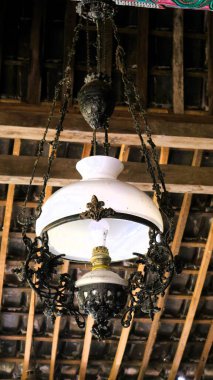 Eski bir Cava lambası, çatıda asılı, Endonezya mirası, mavi gökyüzü sırt çantasıyla, kopyalama alanı